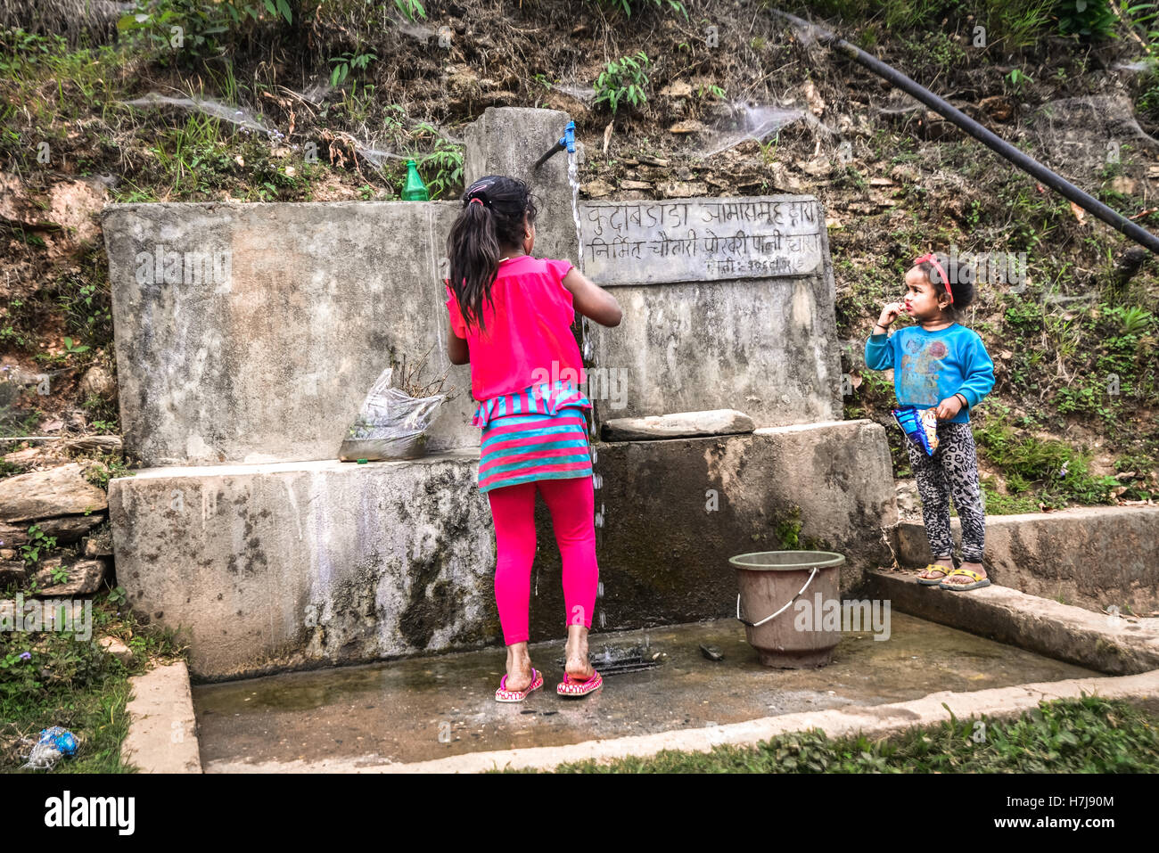 Kinder bei einer kommunalen Wasseraufnahme im ländlichen Panchase, Nepal. Stockfoto