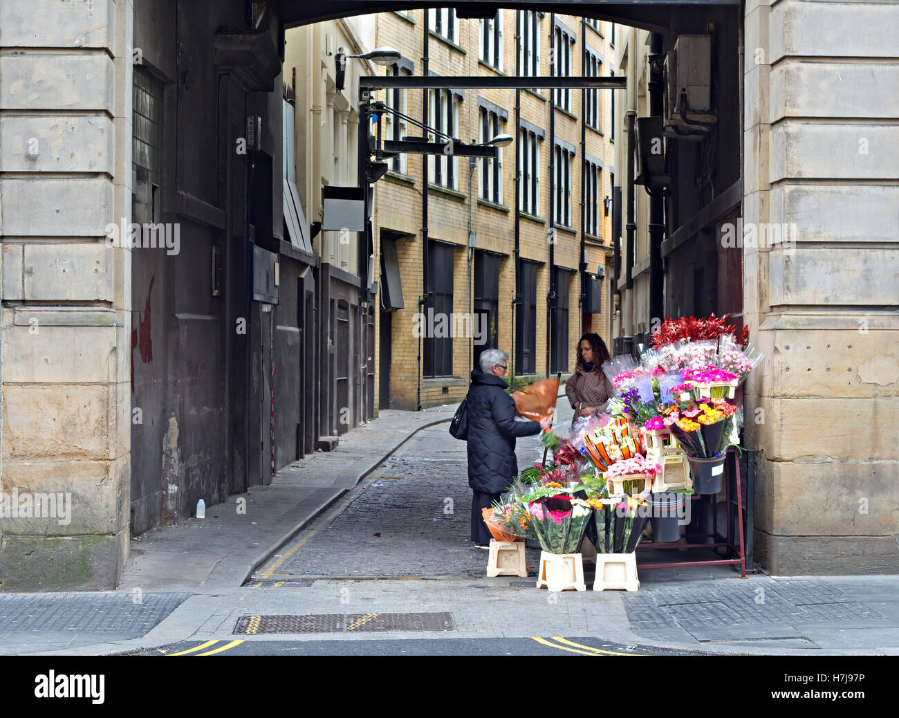 Frau, die Blumen von einem Straße Verkäufer kaufen Stockfoto