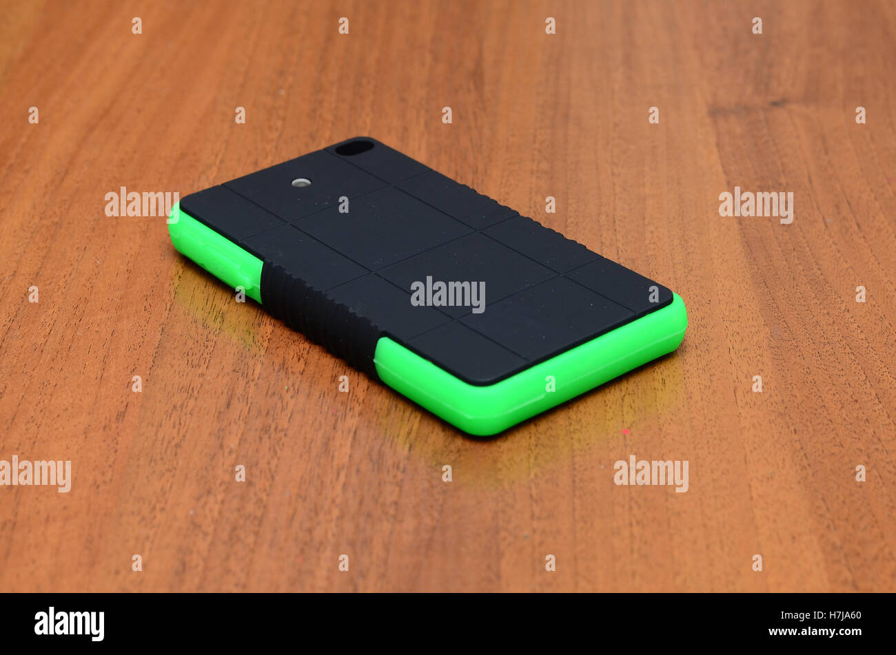 Hält ein intelligentes Telefon während des Ladevorgangs mit solar-Ladegerät in weißem Hintergrund Stockfoto