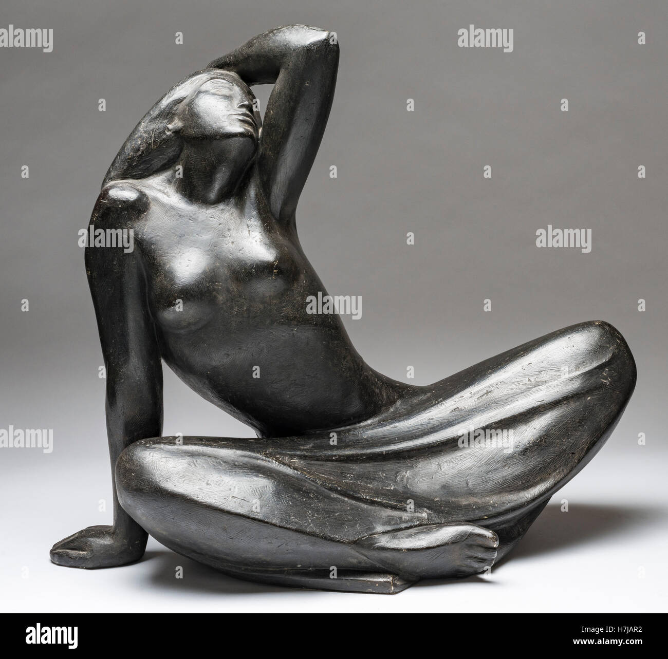Sitzendes junges Mädchen, patiniert Gips Skulptur des französischen Bildhauers Jean Henninger Stockfoto