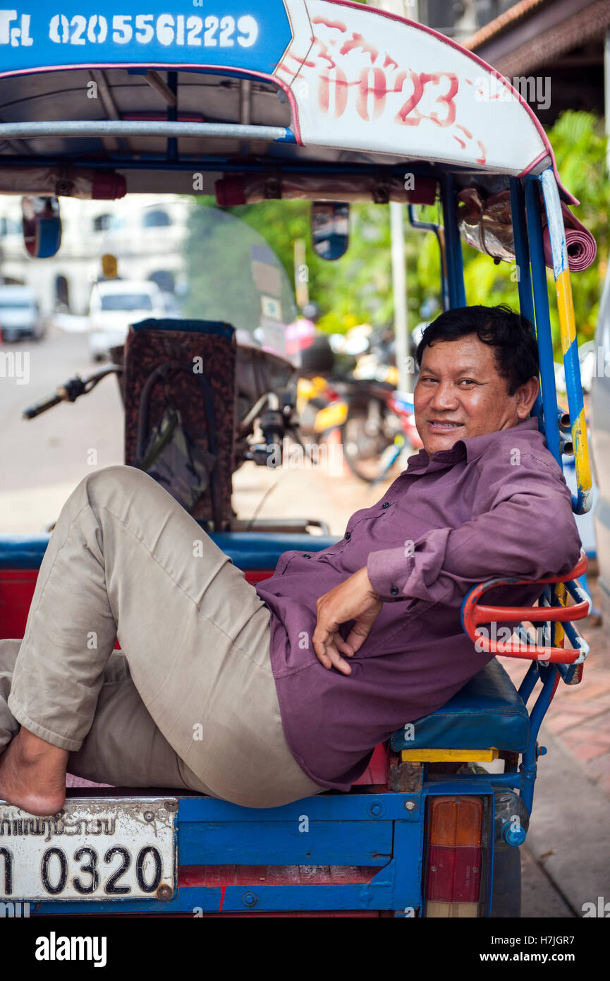 Ein Tuk Tuk Fahrer in der laotischen Hauptstadt Vientiane. Stockfoto