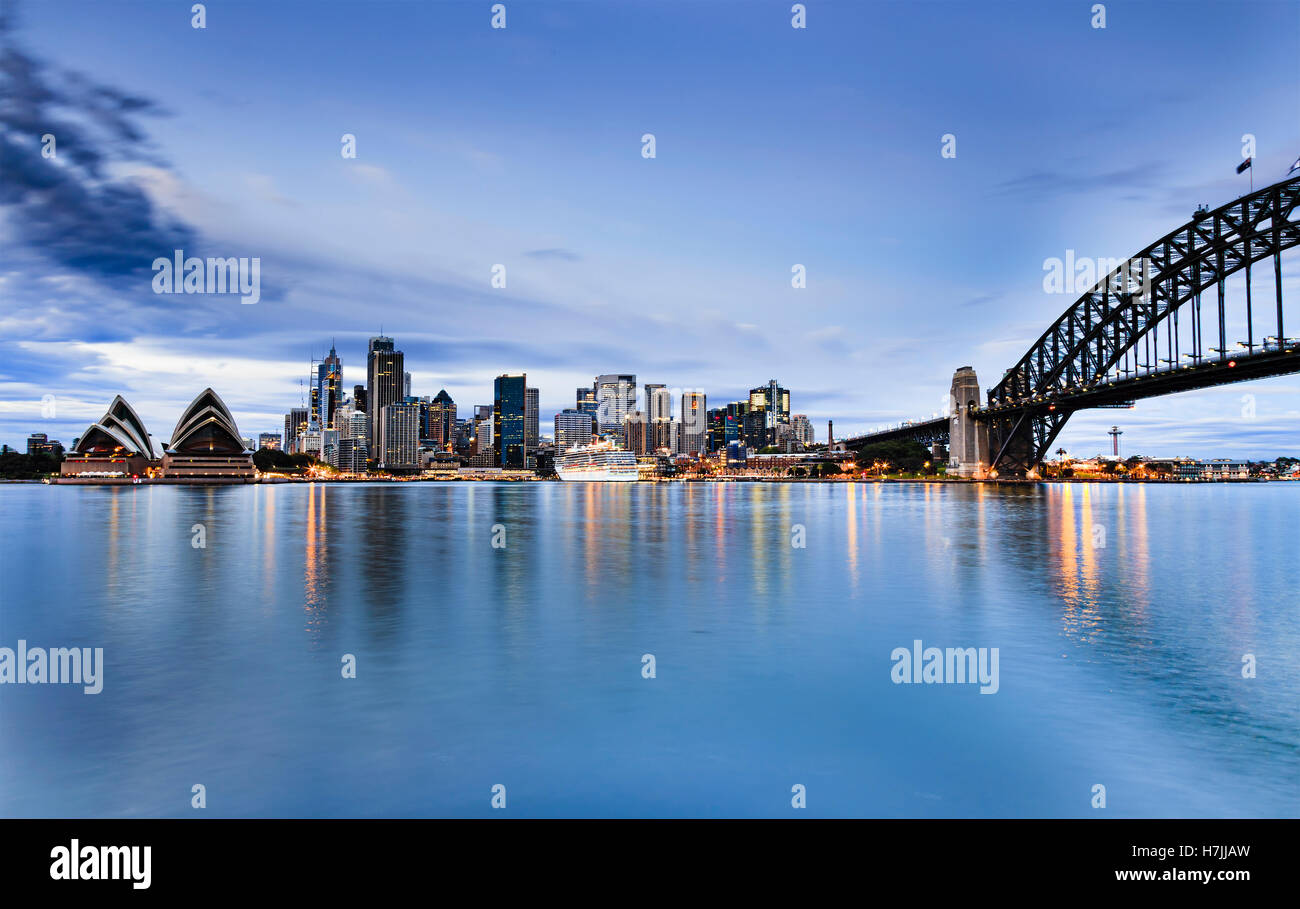 Sydney CBD Sehenswürdigkeiten über Harbou aus Häusern, Brückenbogen zur blauen Stunde des Sonnenaufgangs als Lichter in stillen Wassern spiegeln Stockfoto