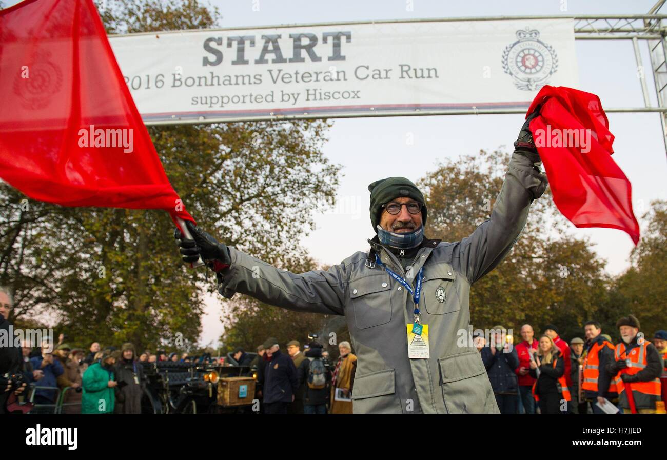 NUR zur redaktionellen Nutzung Eddie Jordan führt das traditionelle zerreißen die rote Flagge zu Beginn der Bonhams London to Brighton Veteran Car Run am Hyde Park Corner in London. Stockfoto