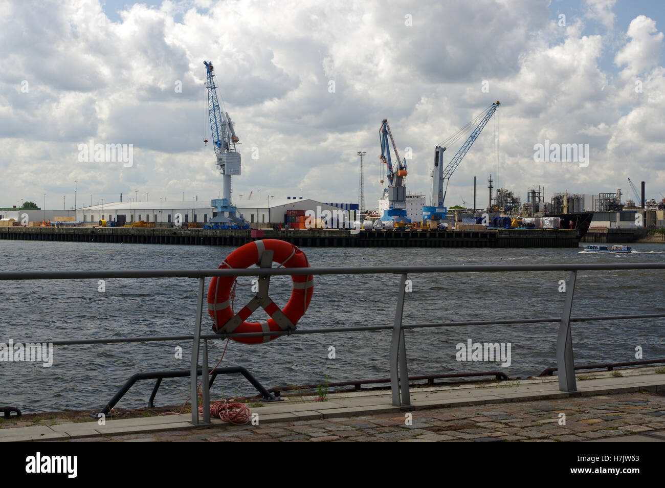 Ein Rettungsring am Kai mit Shif Cran im Hintergrund, Hamburg - Deutschland Stockfoto