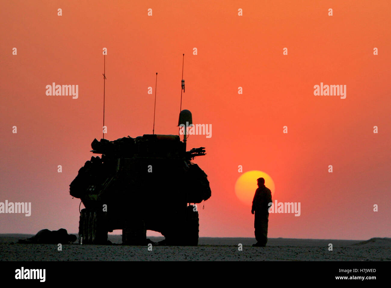 Ein US-Soldat und ein Panzer von der untergehenden Sonne während einer Patrouille Sonnenuntergang während Betrieb zerstören Al Qaida im Norden 1. Mai 2008 in Salah Ad-Din, Irak Silhouette. Stockfoto