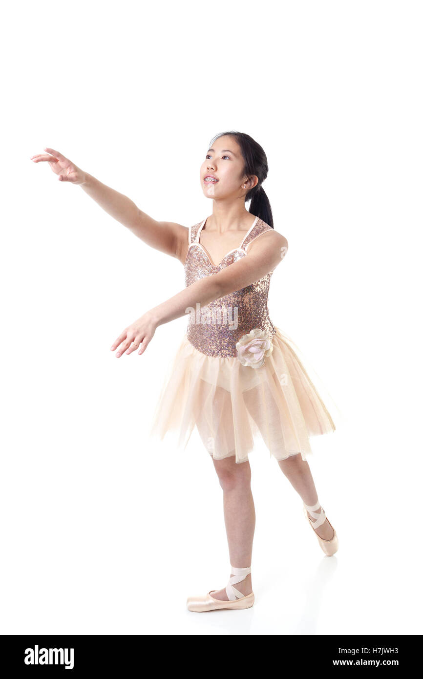 Junge asiatische Ballerina mit geschweiften Klammern eine Ballett Pointe Bewegung ausführen. Isoliert auf weißem Hintergrund. Stockfoto