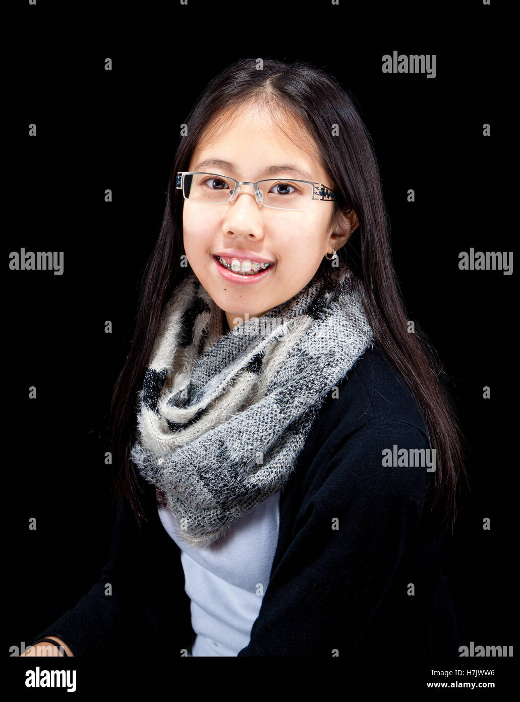 Im Studio Portrait junge asiatische Teen mit Zahnspange, isoliert auf schwarz. Stockfoto