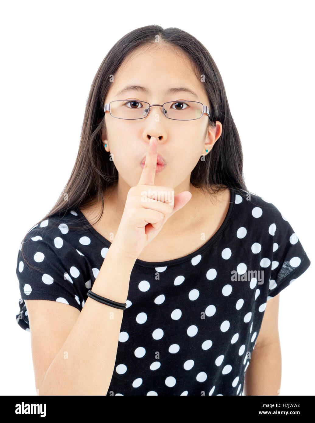 Asiatische Tween mit Finger auf die Lippen in einer Geste zu schweigen Stockfoto