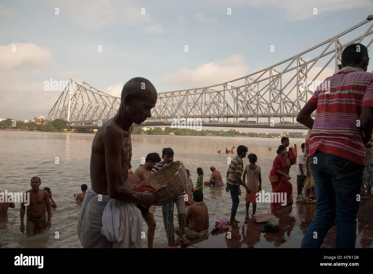 Menschen nehmen morgendlichen Bad in Hooghly River in der Nähe von Howrah Brücke (Rabindra Setu) bei Mallick Ghat Kolkatat Indien Stockfoto