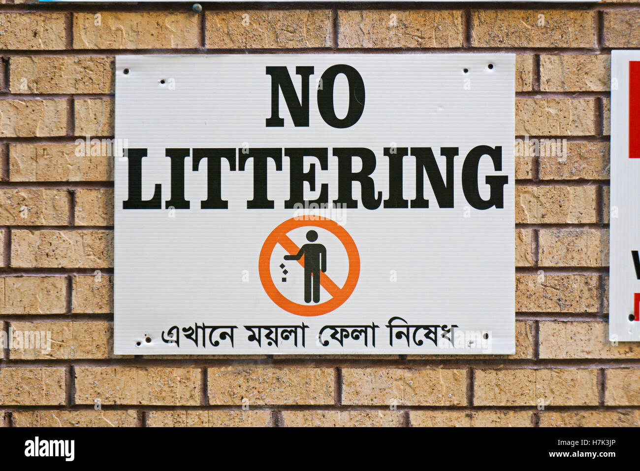 Ein zweisprachigen NO LITTERING Zeichen in Englisch und Bengali. In Jackson Heights, Queens, New York City. Stockfoto