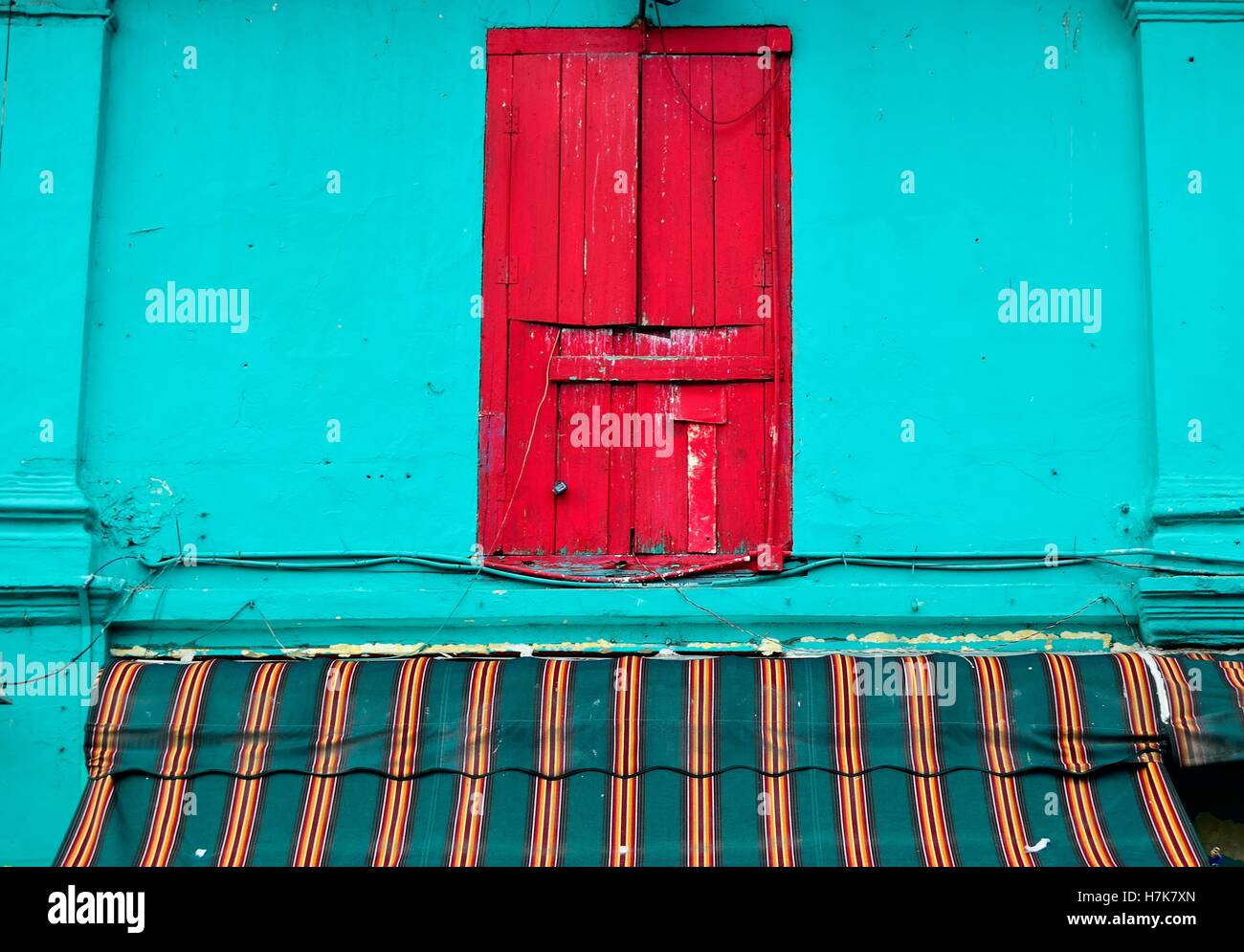 Singapur traditionellen Haus mit roten Fensterläden, blaue Fassade und gestreiften Markise in Dunlop Road, einem Naturschutzgebiet im Stadtteil Little India. Stockfoto
