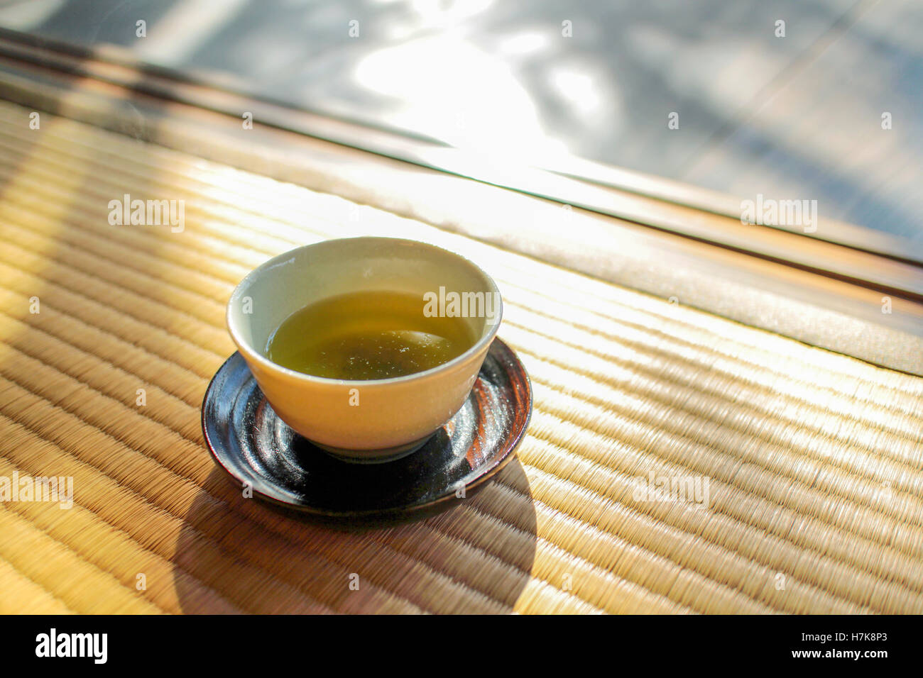 Am Nachmittag Tee-Wellness-Tag. Eine Tasse grüner Tee auf einer traditionellen Matte, tatami Stockfoto