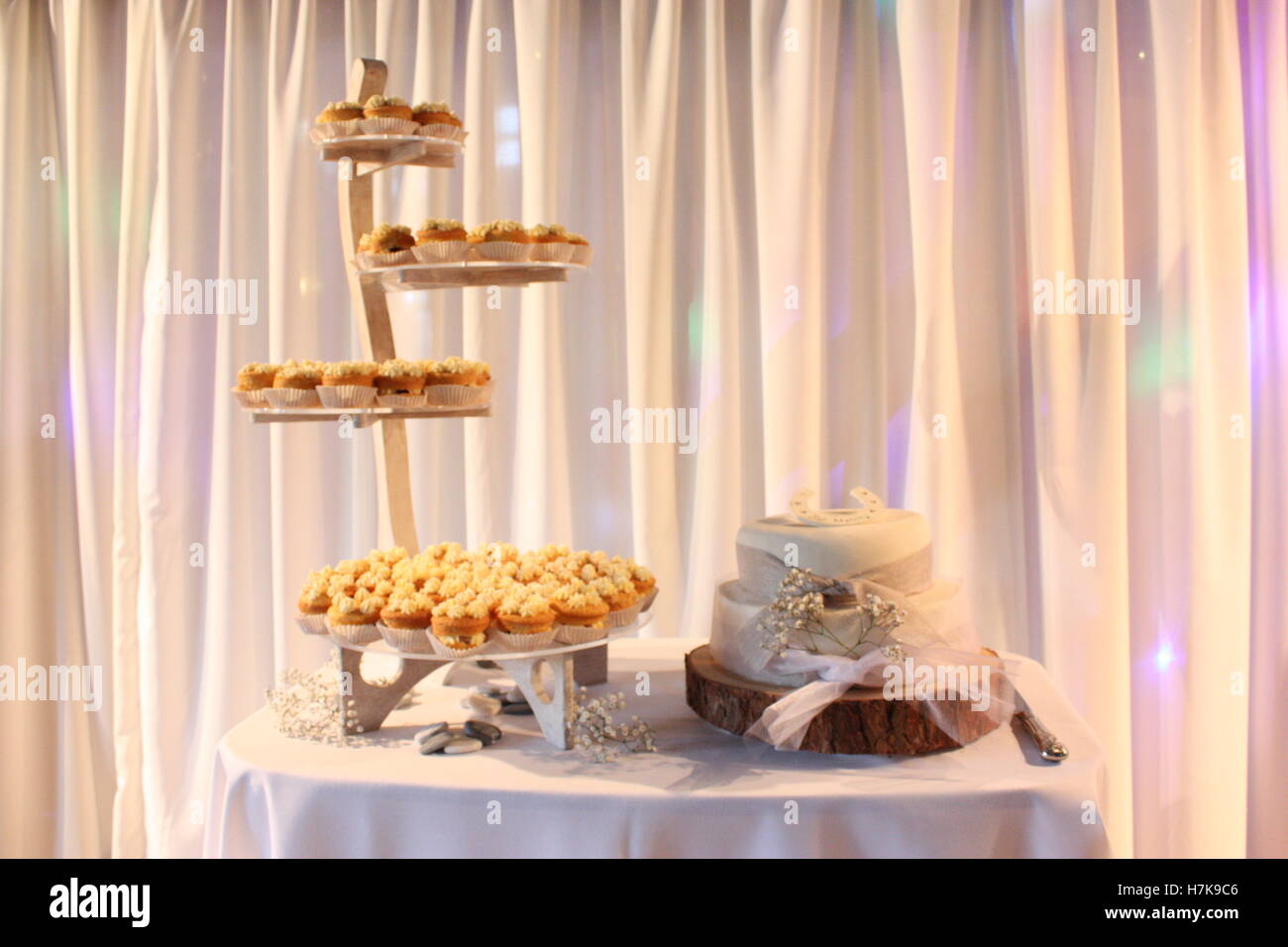 Hochzeitstorte mit Blumen und Band-Log-Stand - Stand der cupcakes Stockfoto