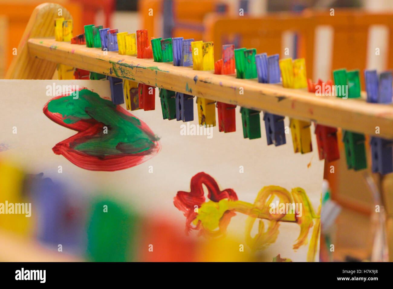 Helle Kindergarten Kinder malten Bilder hängen von Zapfen in Klassenzimmer zu trocknen. Stockfoto