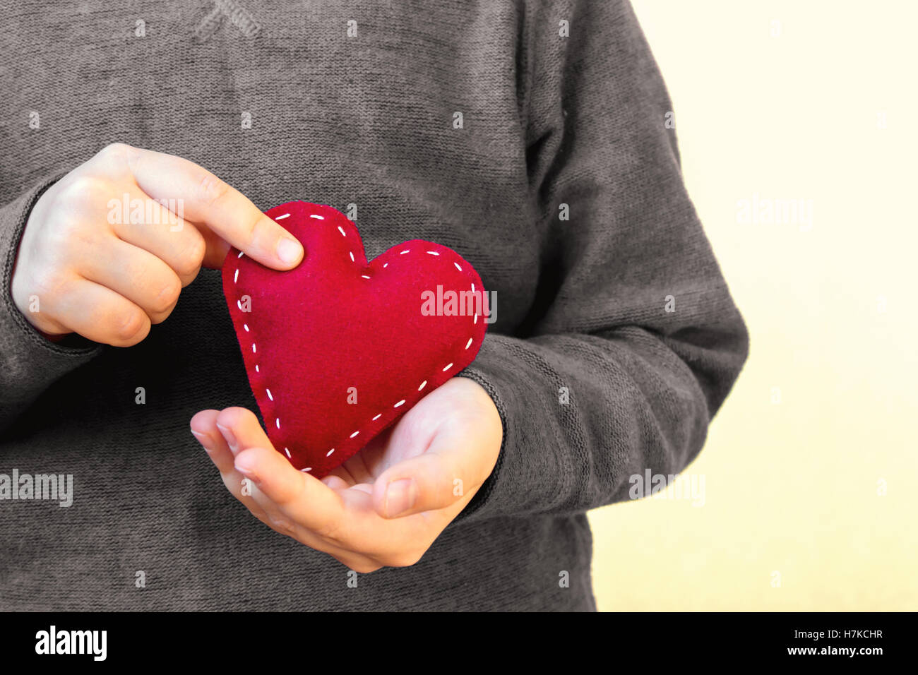 Rotes Herz in Kinderhände, hand gemachte Geschenk, Valentinstag, Freundlichkeit und Familienliebe Konzept Stockfoto