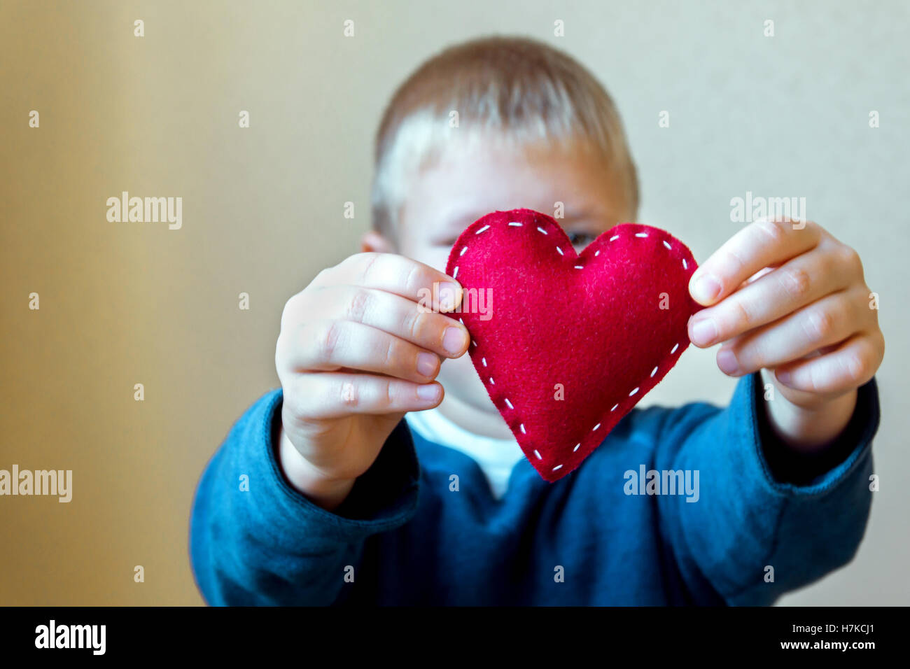Rotes Herz in Kinderhände, hand gemachte Geschenk, Valentinstag, Freundlichkeit und Familienliebe Konzept Stockfoto