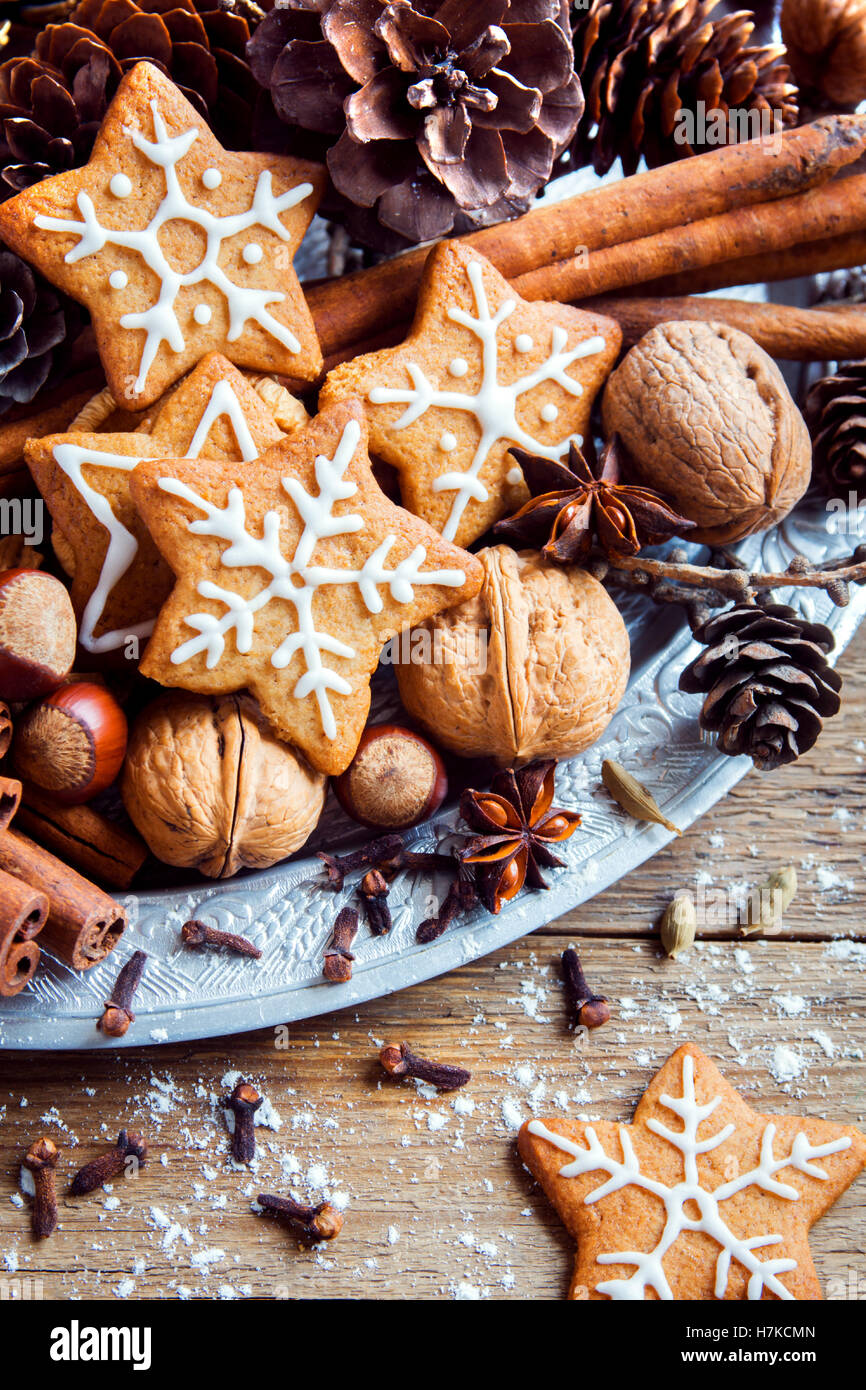Weihnachts-Dekor mit hausgemachten Lebkuchen Cookies Sterne, Zapfen, Nüssen und weihnachtlichen Gewürzen über rustikale Holz Hintergrund Stockfoto