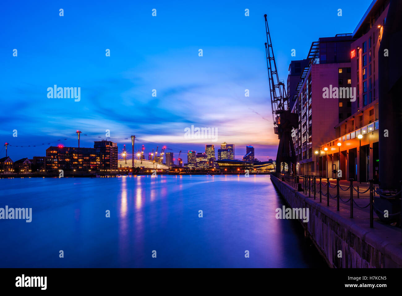 Royal Victoria Dock in London bei Sonnenuntergang mit beleuchteten Stadtbild einschließlich Canary Wharf Stockfoto