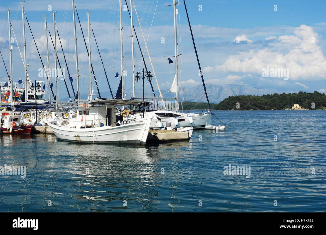 Nidri, Griechenland, 11. Mai 2013: Landschaft mit blauen Hafen, grüne Küste, großes Fischerboot und Yachten im Ionischen Meer, Griechenland. Stockfoto