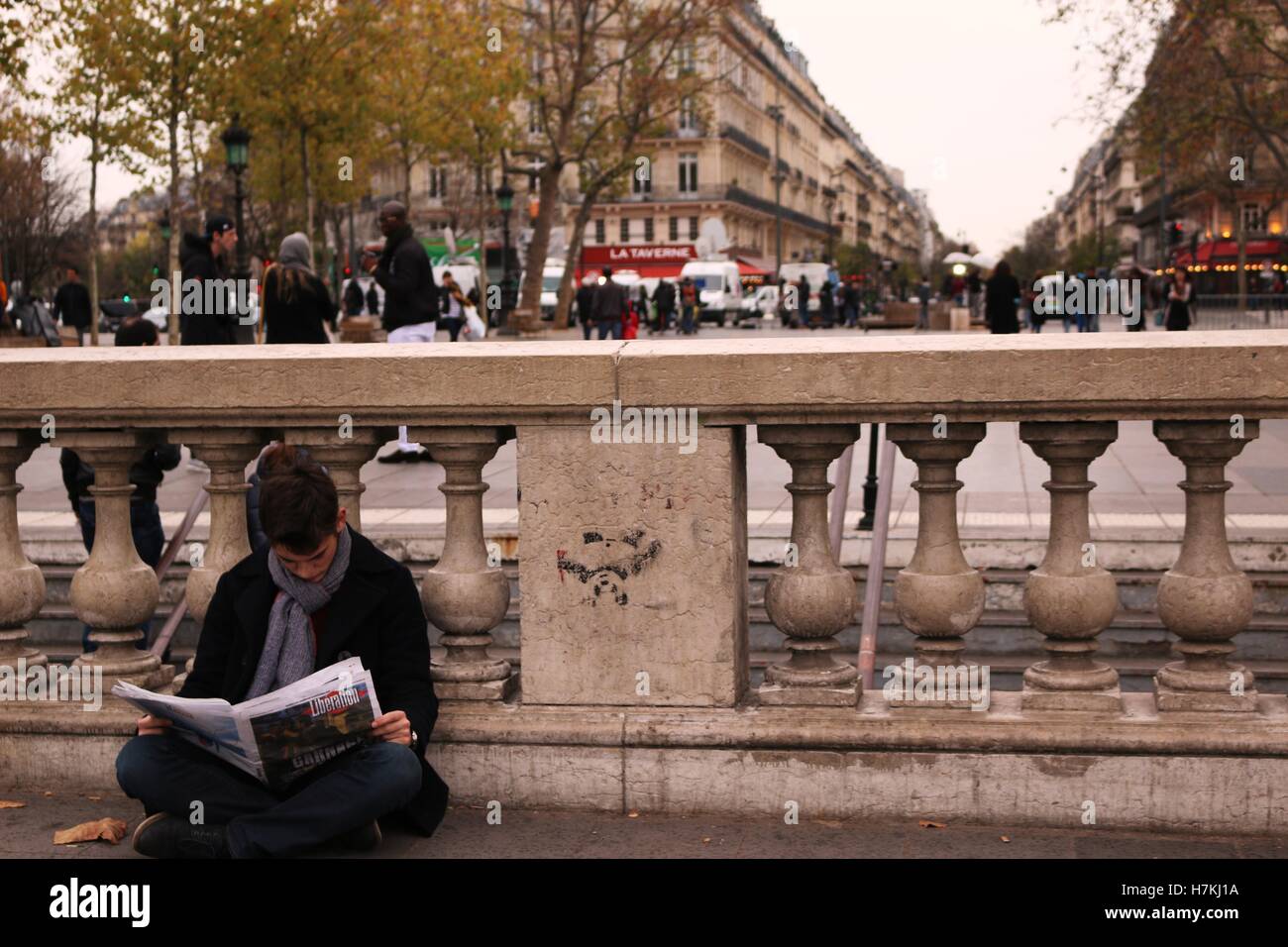 Ein Mann liest eine Sonderausgabe Zeitung einen Tag nach den Terroranschlägen von Paris Stockfoto