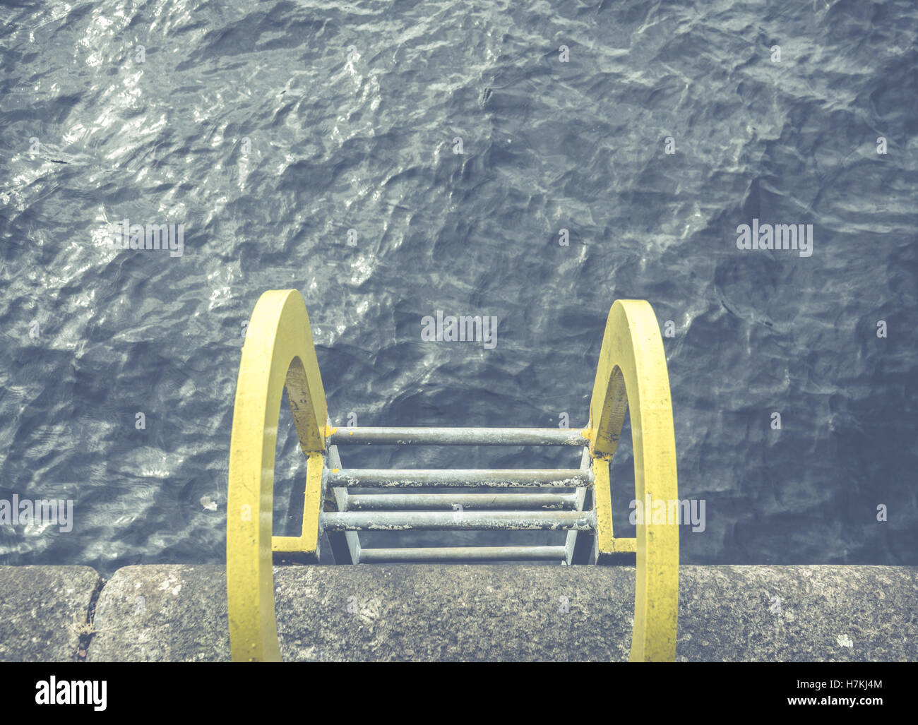 Eine gelbe Leiter ins Blue Ocean Wasser an einem Hafen Stockfoto