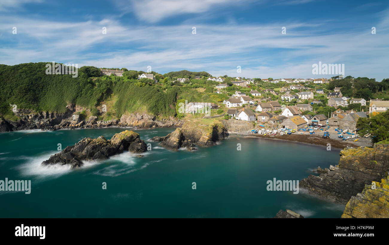 Hütten, Boote, Klippen und Felsen an der malerischen Küste Cadgwith in Cornwall glänzen in der Morgensonne, England, UK Stockfoto