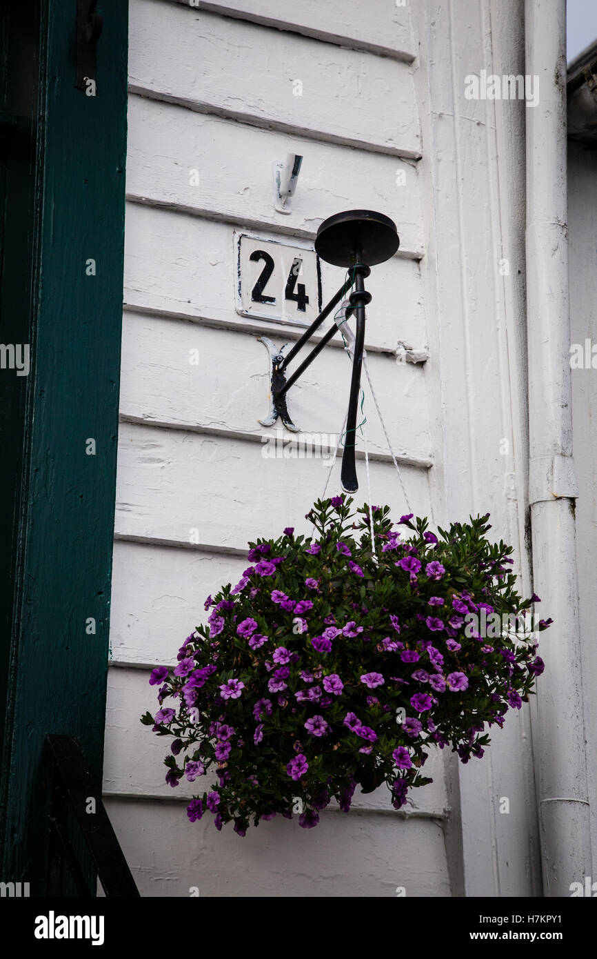 Ein Haus in der Altstadt von Stavanger, Norwegen mit der Zahl "24" und einem hängenden Korb mit Blumen. Stockfoto