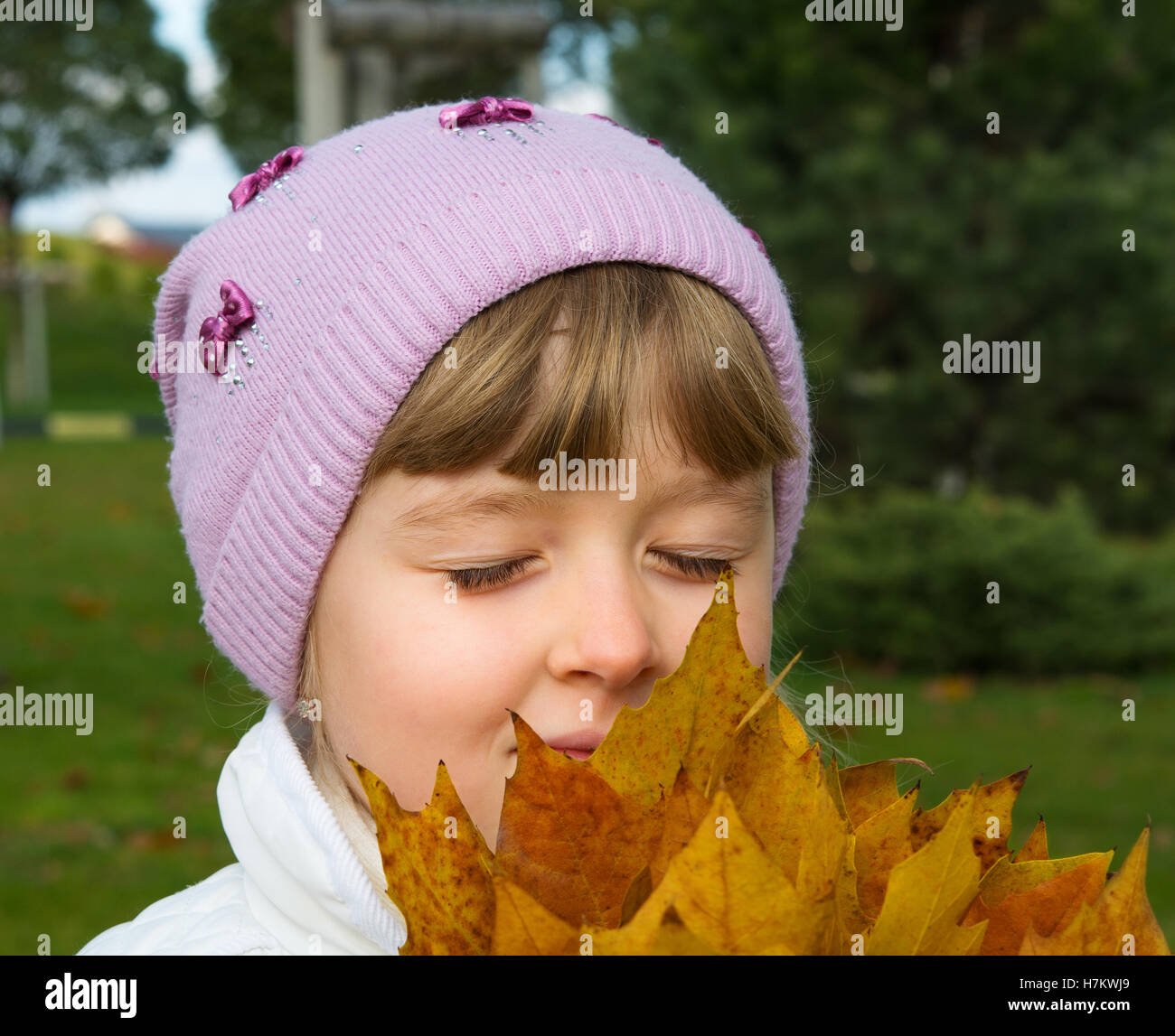 Kind spielt mit Herbstlaub Stockfoto