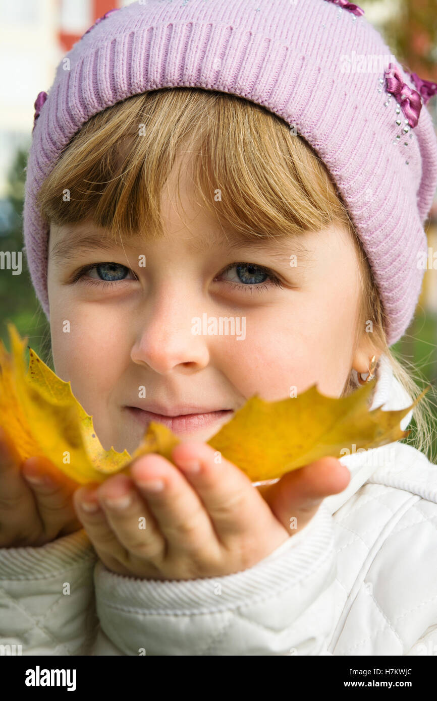 Kind spielt mit Herbst gelbe Blätter Stockfoto