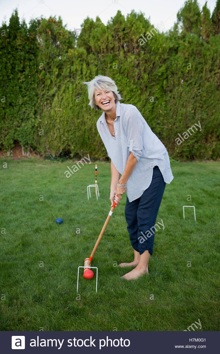 Begeisterte Frau spielen Krocket Sommer Gras Stockfoto