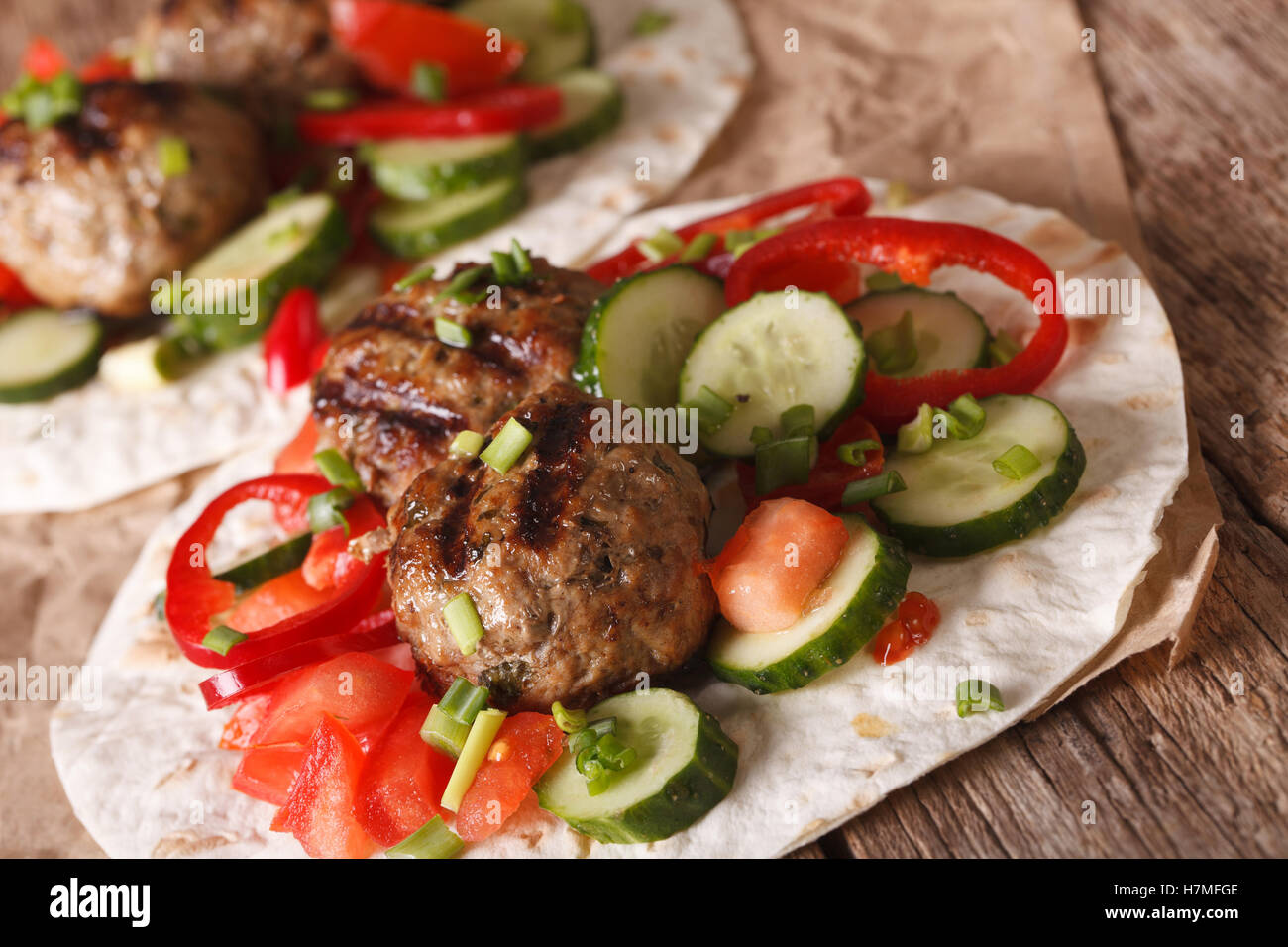 Arabische Lebensmittel: Frikadellen mit frischem Gemüse auf ein flaches Brot hautnah auf dem Tisch. horizontale Stockfoto
