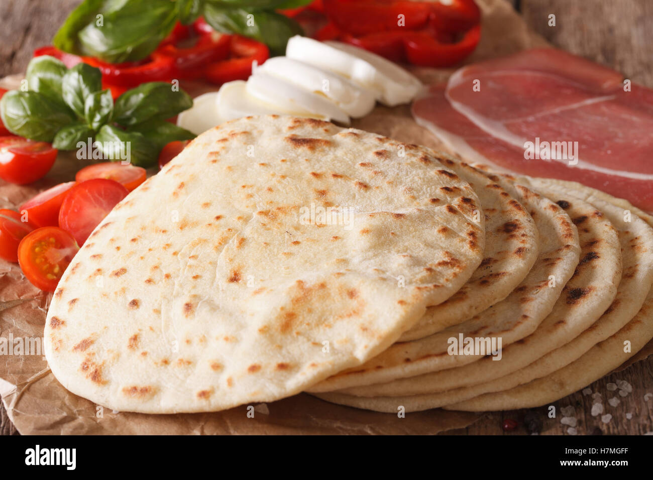 Italienische Piadina flaches Brot, Schinken, Käse und Gemüse auf einer Tabelle Makro. horizontale Stockfoto