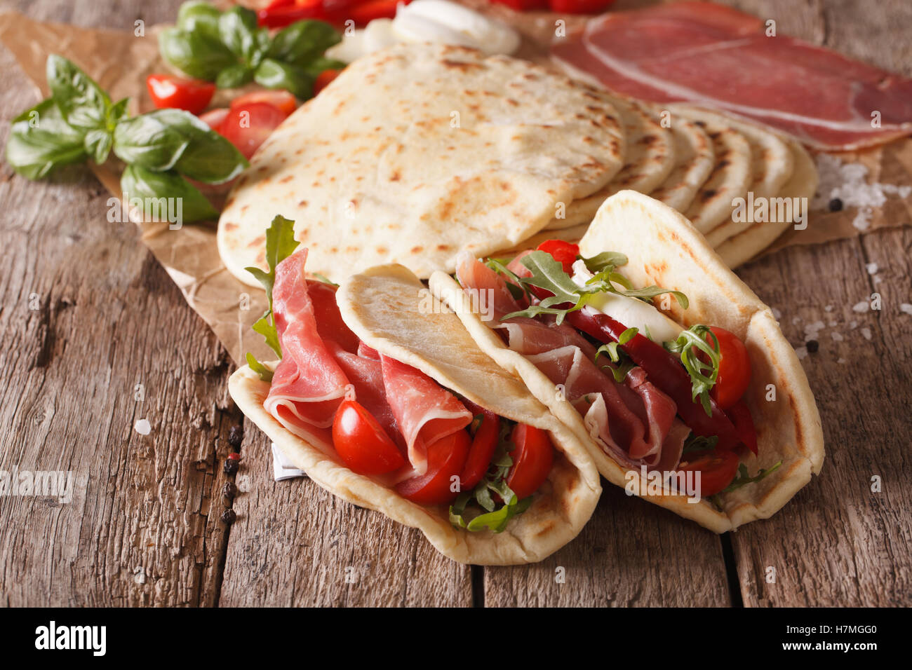 Leckere italienische Piadina gefüllt mit Schinken, Käse und Gemüse Nahaufnahme auf dem Tisch. Horizontale Stockfoto