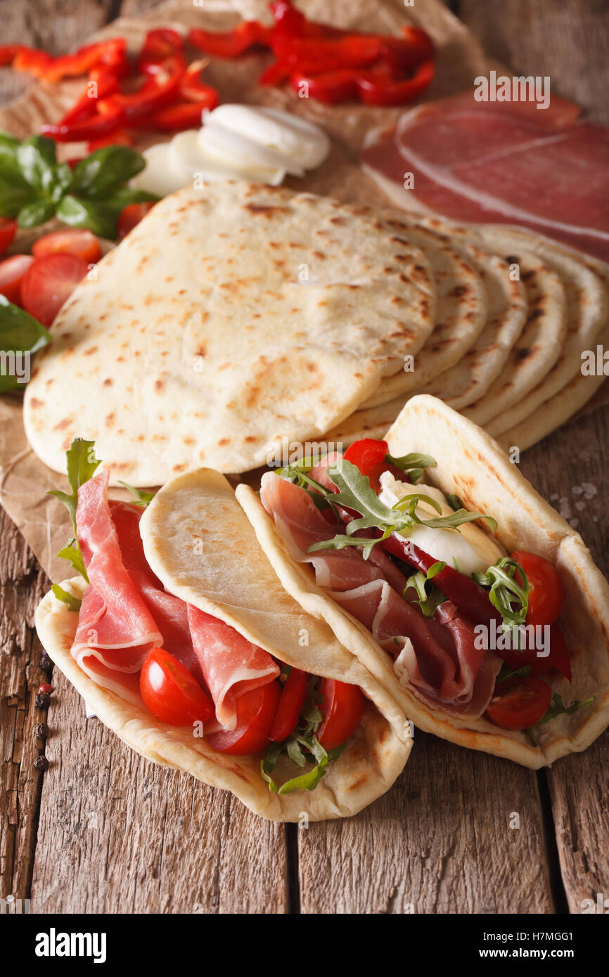 Leckere italienische Piadina gefüllt mit Schinken, Käse und Gemüse Nahaufnahme auf dem Tisch. vertikale Stockfoto