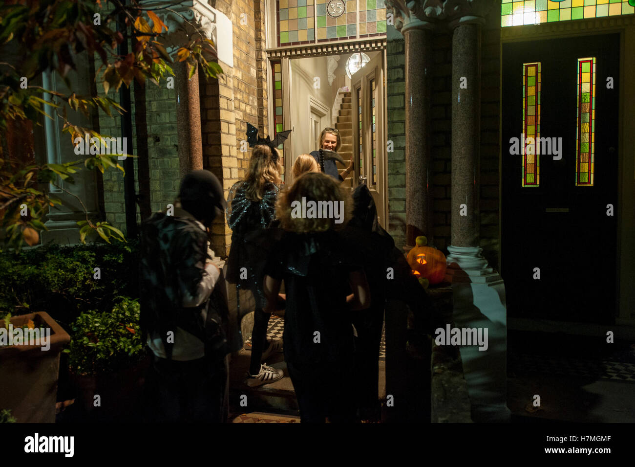 Trick oder Treaters klopfen an eine Tür in einem Londoner Wohnhaus Stockfoto