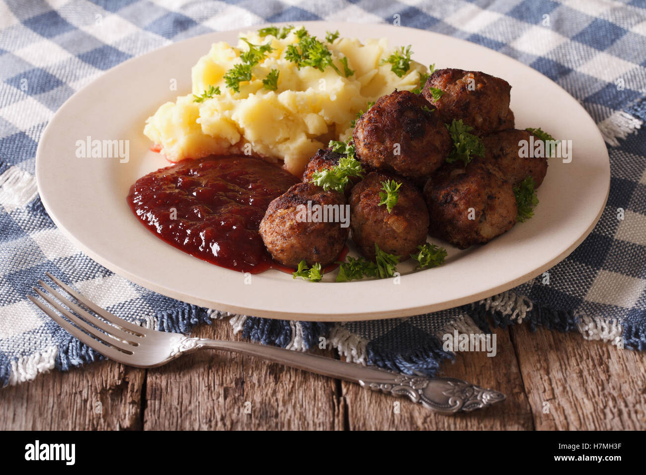 Schwedische Küche: Frikadellen, Preiselbeer-Sauce mit Kartoffeln garniert auf einer Platte Nahaufnahme. horizontale Stockfoto