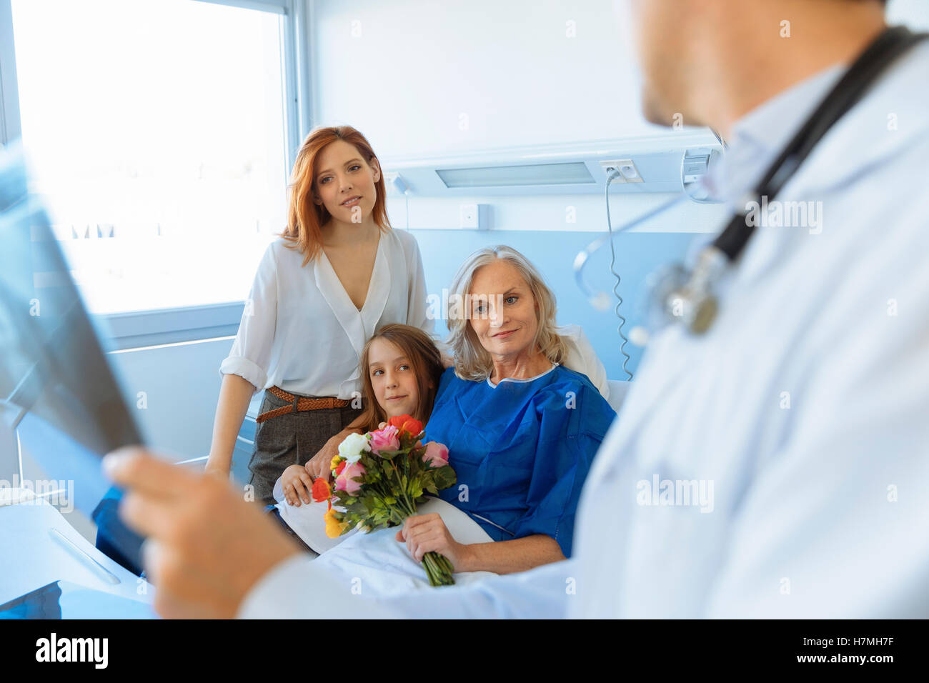 Familienbesuch bei Oma im Krankenhausbett Stockfoto