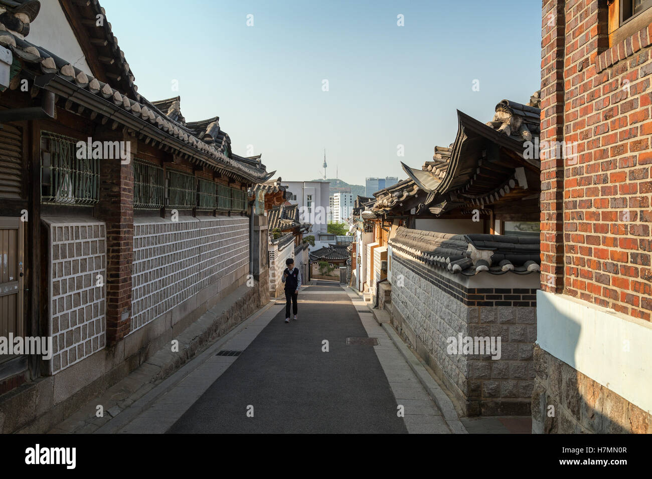Schüler zu Fuß in einer kleinen Gasse im Bukchon Hanok Village in Seoul, Südkorea. Stockfoto