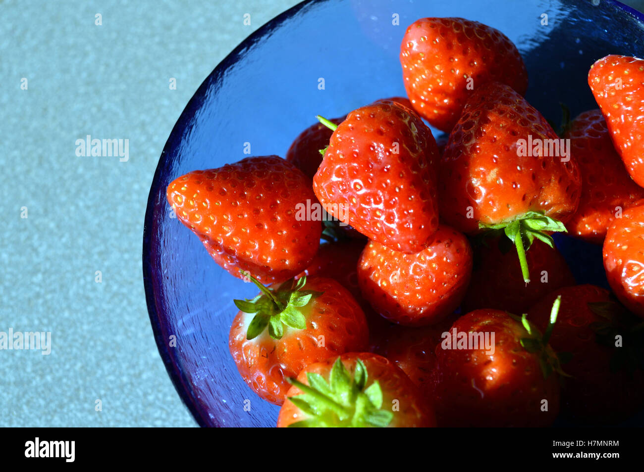Frische Erdbeeren in eine blaue Glasschale Stockfoto