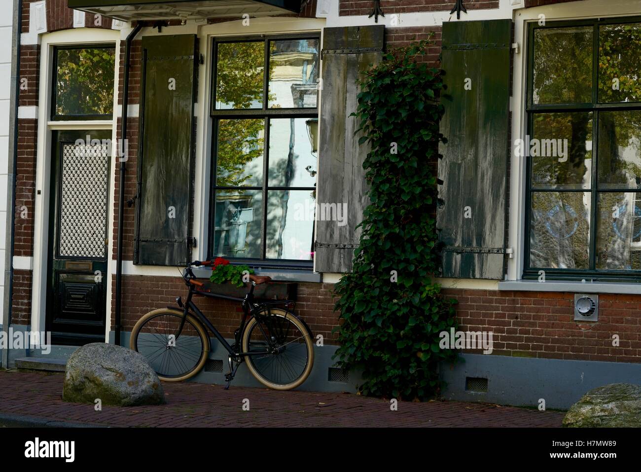 typische Hollandrad vor einigen Fenstern eines Hauses Stockfoto