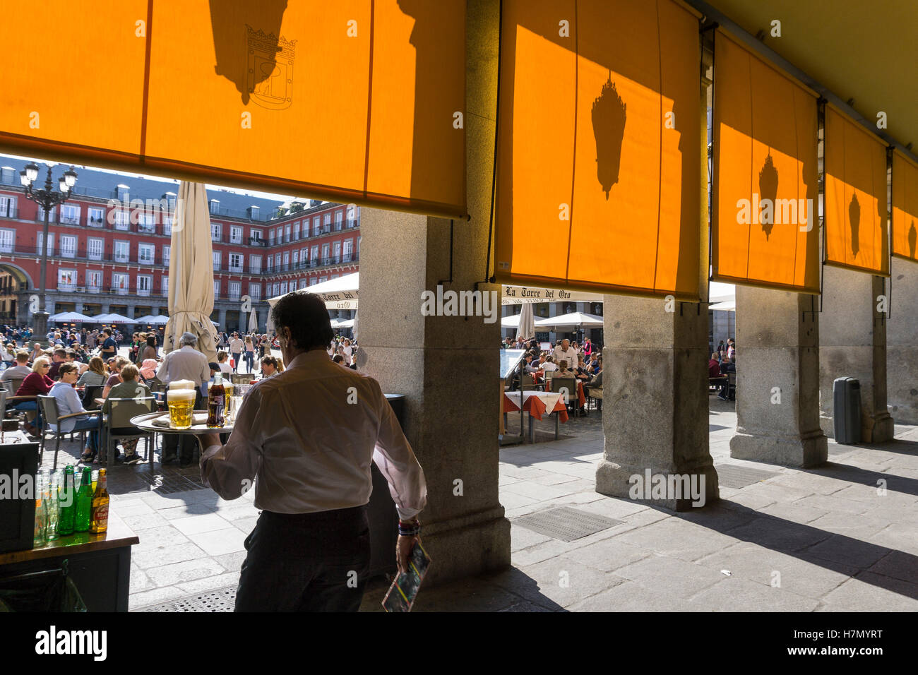 Ein Kellner trägt Getränke Café-Tischen auf der Plaza Mayor im Zentrum von Madrid, Spanien Stockfoto