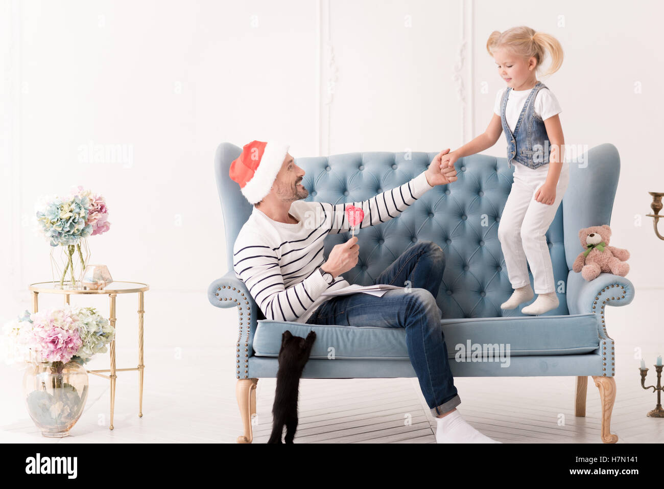 Netter fröhlicher Mann im Besitz einer Hand seiner Tochter Stockfoto