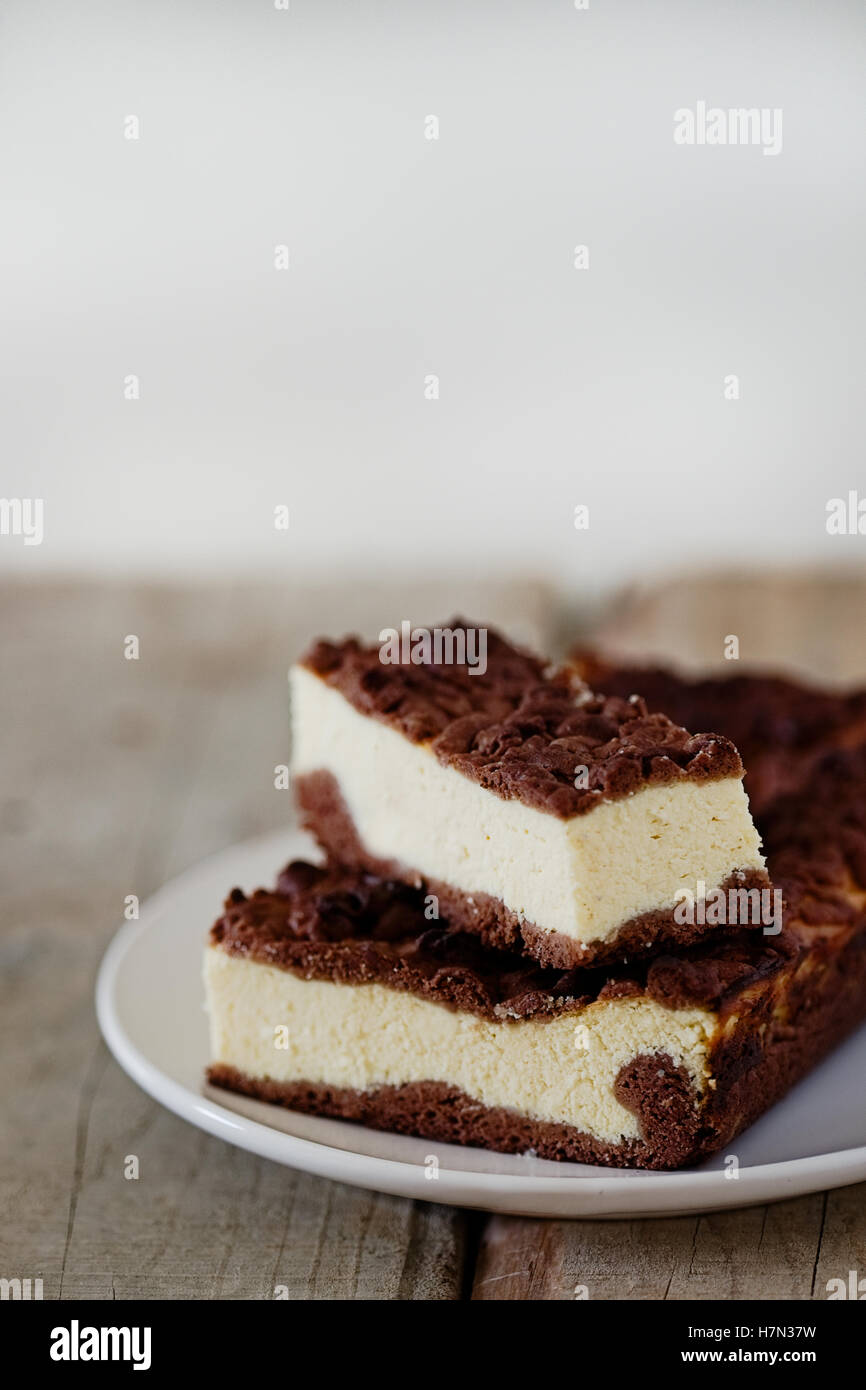 Stück Käsekuchen mit Schoko Mürbeteig und Schokolade zerbröckeln. Holztisch. Freitext Raum Hintergrund. Stockfoto