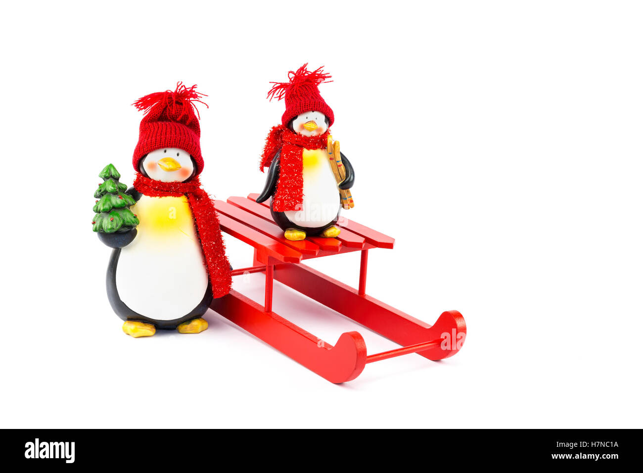 Mutter und Kind Pinguin mit Schlitten und Weihnachtsbaum isoliert auf weißem Hintergrund Stockfoto
