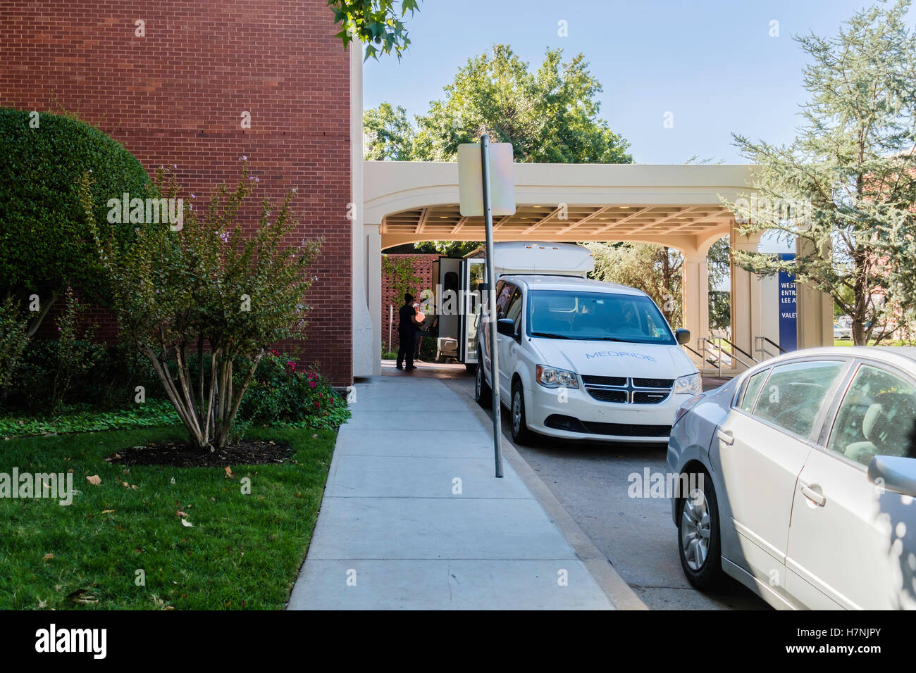 Ein Medride Rollstuhl van und Personal wartet auf einen Patienten außerhalb St. Antonius Hospital in Oklahoma City, Oklahoma, USA. Stockfoto