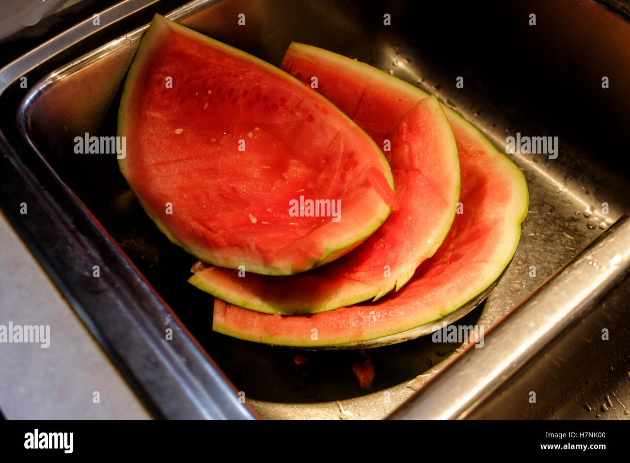 Ein Stapel von Wassermelone Schwarten bereit für den Müll in einer Edelstahlwanne nach dem Schneiden. Stockfoto