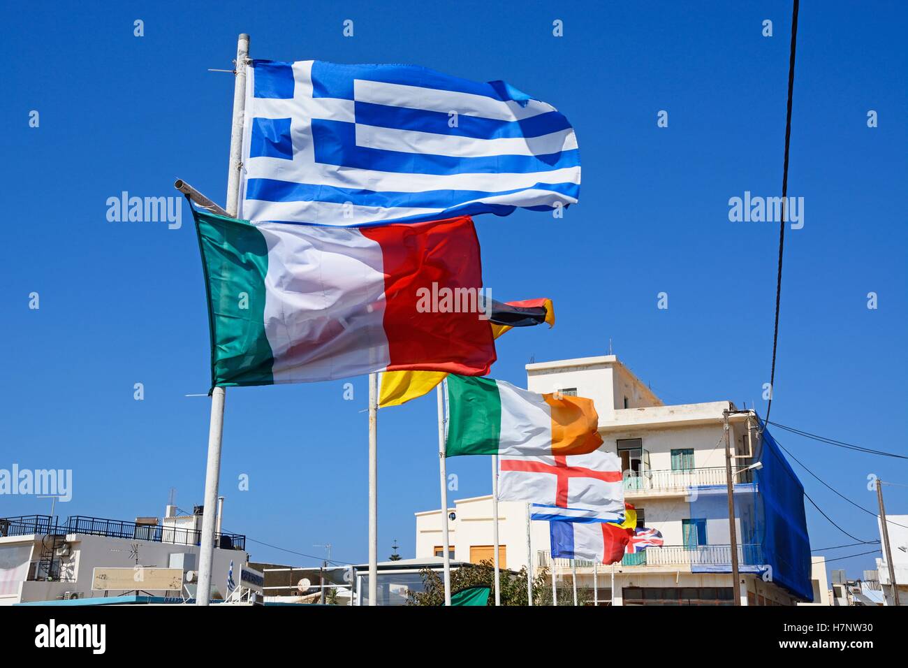 Reihe von europäischen Flaggen mit Stadtgebäude nach hinten, Sissi, Kreta, Europa. Stockfoto