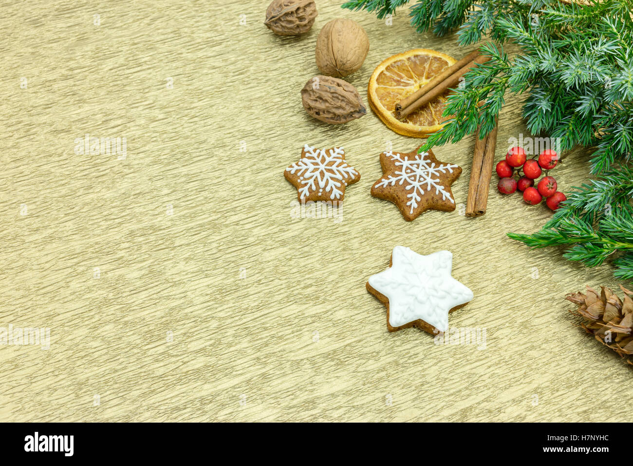 hausgemachter Lebkuchen mit Tannenzweigen Baum, Gewürzen und roten Beeren auf Gold Geschenkpapier Stockfoto