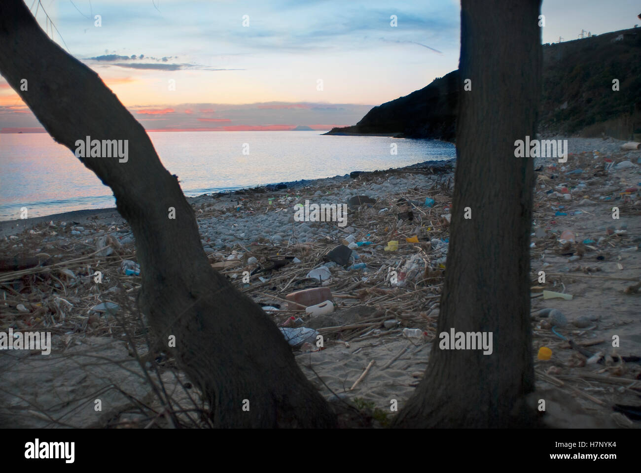 Sonnenuntergang auf dem Meer an einem verschmutzten Strand Stockfoto