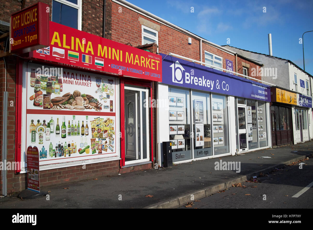 östliche Europäische Nahrung Mini Markt und Immobilienmakler-Shops auf einer Straße in Wigan England uk Stockfoto